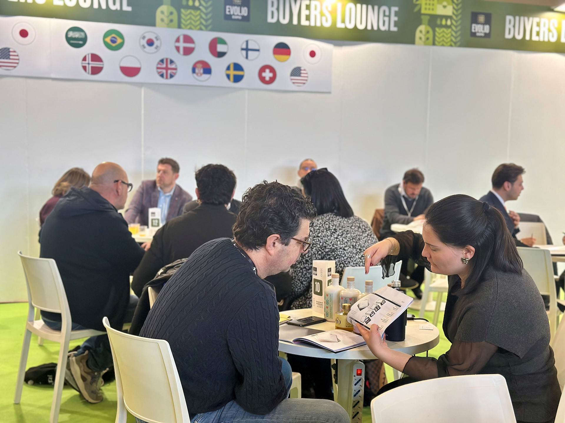 Foto d'archivio di Evolio Expo: operatori a colloquio ai tavoli della Buyers Lounge, con bottiglie d'olio